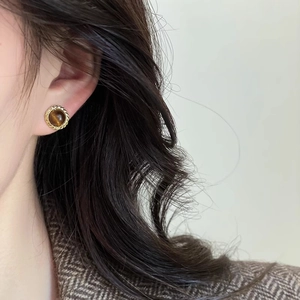 Boucles d'oreilles rondes dorées avec pierre œil de tigre et bordure tressée