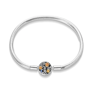 Detailed close-up of a silver snake chain bracelet with a carved sun and tree motif clasp