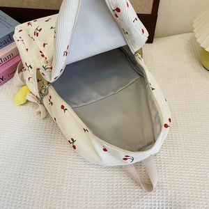 Internal view of cherry print corduroy backpack showing spacious grey lining and compartments