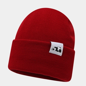 Detail of red ribbed knit beanie showing the panda patch and soft woven texture