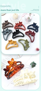 Macro shot of matte and glossy floral hair claws in various colors with decorative props