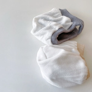 Détail de protège-oreilles en polaire pour bébé avec bords côtelés en blanc et beige