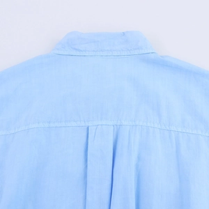 Detailansicht des gefalteten Rückendesigns auf einem hellblauen Baumwollhemd für Damen