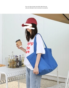 Side view of a large blue washed canvas tote bag used in an outdoor casual setting