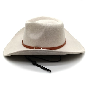 Detail of cream western cowboy hat showing brown leather band and adjustable chin strap