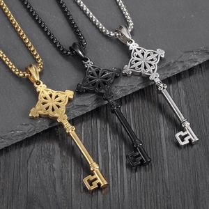Retro key-shaped necklaces in gold, black, and silver finishes on a stone background