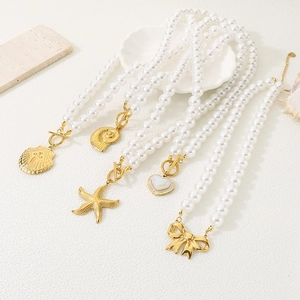 Detailed close-up of pearl bracelets with gold shell, starfish, and heart charms