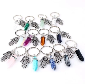 Macro shot showing diverse Hamsa Hand crystal keychains with various gemstone hexagonal pillars