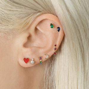 Close-up of ear stacking with heart, moon, and colorful pear-shaped gemstones earrings