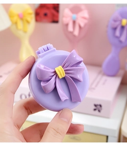Vue détaillée du joli nœud 3D sur une brosse à cheveux pliante violette portable