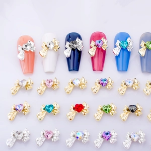 Macro view of alloy bow nail charms with colorful heart-shaped rhinestones and crystals