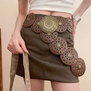 Macro detail of retro bohemian brown leather belt with gold embossed floral metal buckles