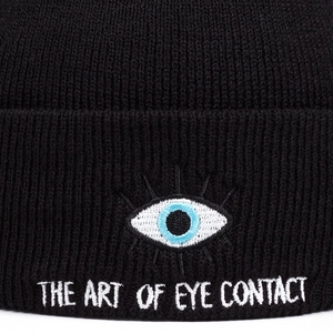 Bonnet en tricot noir avec broderie œil et slogan THE ART OF EYE CONTACT