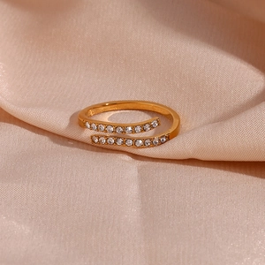 Detailed view of an adjustable gold-plated ring with shimmering cubic zirconia on silk