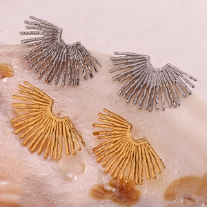 Macro detail of sunburst fan-shaped earrings in 18K gold and silver plated metal