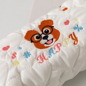 Close-up of quilted pencil case with cute dog embroidery and colorful happy text