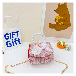 Close-up of pink tweed girls' mermaid bag with pearl handle and sequins in gift setting