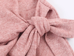 Détail du tissu en maille côtelée rose chiné avec un nœud décoratif élégant