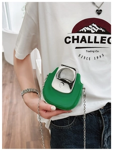 Detailed close-up of a green mini crossbody bag with silver metal handle and chain strap