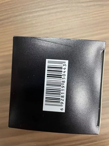 Close-up of black packaging box with a barcode sticker on a wooden background