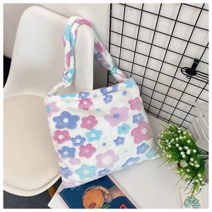 Plush tote bag with colorful floral pattern shown on a chair in a cozy lifestyle setting