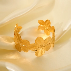 Detailed macro shot of vintage gold flower patterns on a stainless steel bangle