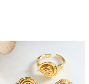 Macro detail of golden rose shaped rings featuring fine texture and central gemstones