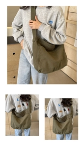 Detailed close-up of dark green canvas messenger bag showing wide strap and front pocket