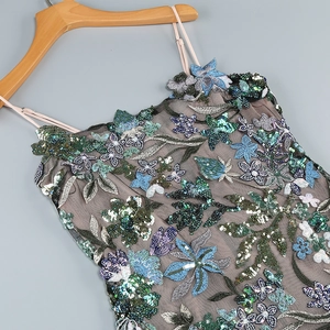 Détail de la broderie florale à paillettes et du mesh sur robe dentelle à bretelles