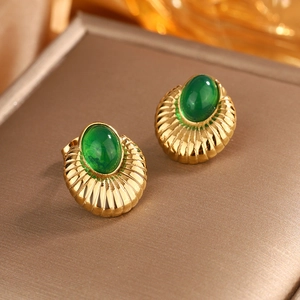 Detail of 18K gold plated earring featuring a green gemstone and pleated vintage texture