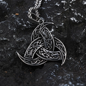 Gros plan détaillé du pendentif Viking Cornes d'Odin en acier sur une pierre noire