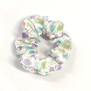 Detail of silk-like satin scrunchie with Easter bunny patterns and floral prints