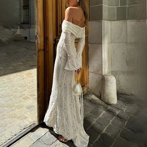Dettaglio di elegante abito in pizzo bianco con spalle scoperte e lunghe maniche a campana