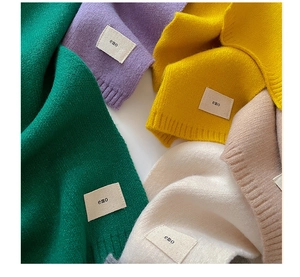 Close-up of soft knitted scarves showing various colors and detailed woven texture