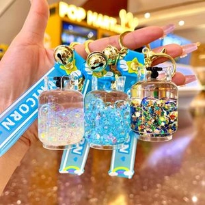 Detail of gas tank shaped liquid quicksand keychain with pink and blue glitter finish