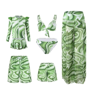 Flat lay of green marble pattern family swimwear set including swimsuits and sarongs