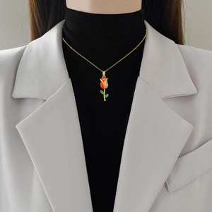 Elegante collana in acciaio al titanio dorato con pendente a rosa e diamanti brillanti