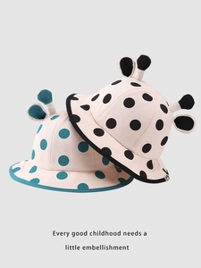 Dettaglio di due cappelli da sole per bambini a pois con orecchie in beige e nero