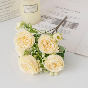 Détail de roses artificielles jaune pâle avec feuilles vertes et boutons de rose réalistes