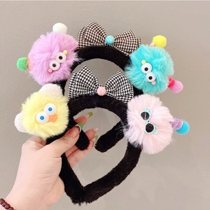 Detail of colorful plush monster headbands with big eyes and checkered bows decoration