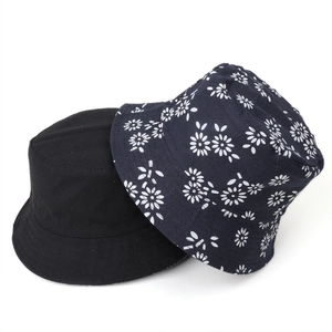 Reversible cotton bucket hats in solid black and navy blue floral daisy print for sun protection