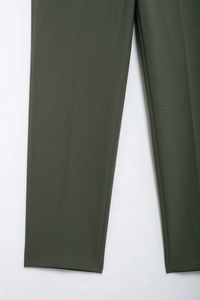 Détail du pantalon tissé vert armée montrant la texture du tissu et la coupe droite