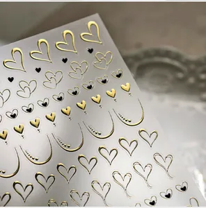 Macro shot of 3D embossed gold heart nail art stickers with metallic line patterns