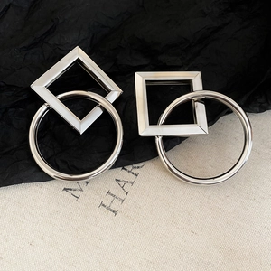 Detailed view of silver interlocking square and circle geometric stud earrings