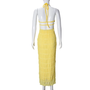 Back view of yellow halter dress showing backless design and pleated fabric texture