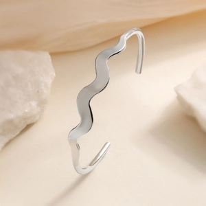 Minimalist silver wavy open bangle in polished stainless steel for modern women