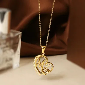 Macro shot of gold titanium heart pendant with Mom lettering and zircon stones