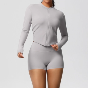 Close-up of slim fit light grey yoga set with zip-up long sleeve top and high waist shorts