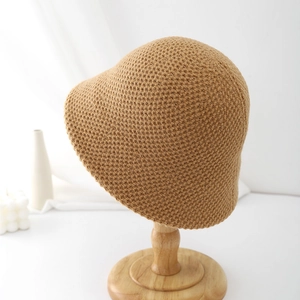 Détail d'un chapeau bob en tricot kaki montrant la texture épaisse des mailles sur support