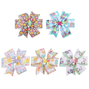 Detailed view of handmade Easter bow hair clips with bunny and egg patterns on grosgrain